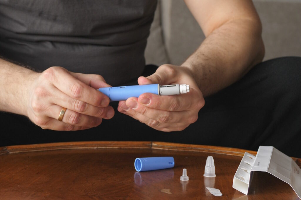 man prepping for ozempic injection