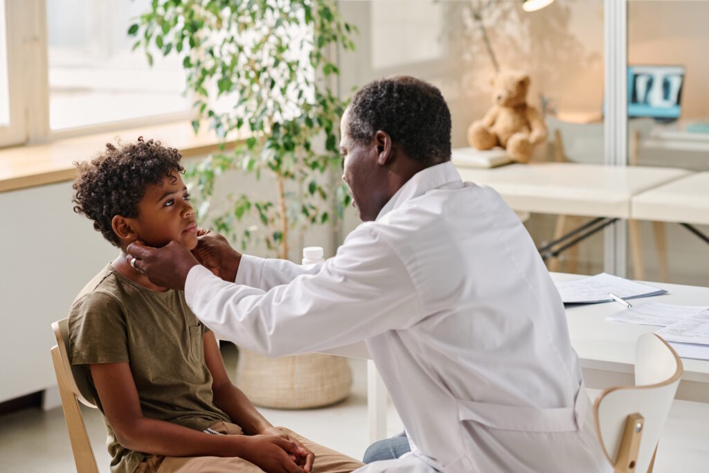 doctor examining boy's sore throat